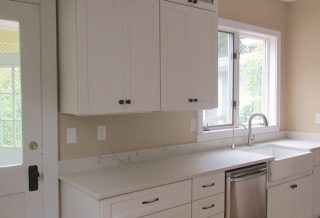 White upper cabinets with crown mould in kitchen remodel