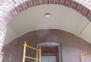 Curved porch ceiling covered in white beadboard on award-winning historic preservation construction project