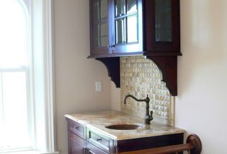 Glass fronted wine cabinet and marble topped sink in historic restored Victorian farmhouse in East Central IL