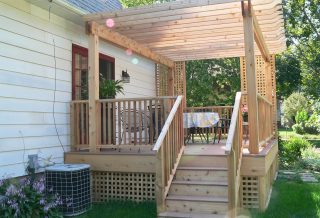 New cedar deck construction with lattice, pergola, stairs, and rails.