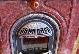 Restored mottled red firepiece and mantelpiece with decorative grillwork in historic restoration of Victorian Italinate Homestead in East Central IL
