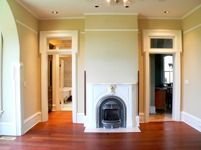 Fireplace, mantelpiece, and restored hardwood floors in historic restoration of Victorian Italinate Homestead in East Central IL