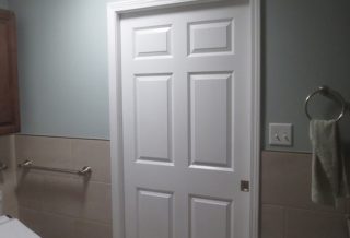 White panelled sliding bathroom door in home addition in Urbana IL