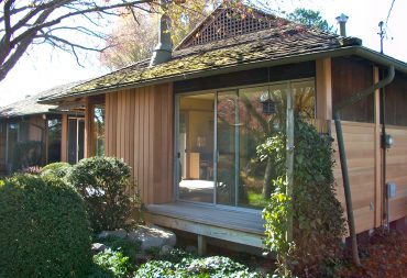 Exterior siding renovation with alternating colors of clear cedar siding, trim, and stucco panels revived the original beauty of this architect-designed, Japanese style home.