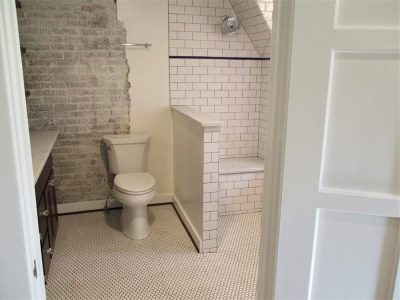 Exposed brick with organic edges in master bathroom remodel.