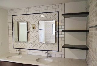 Floating shelves, cantilevered countertops, exposed brick with organic edges, period tile, and sophisticated fixtures in master bathroom remodel.