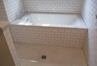 Tiled bathtub and shower in master bathroom remodel.