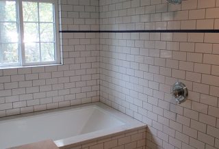Tiled bathtub and shower in master bathroom remodel.
