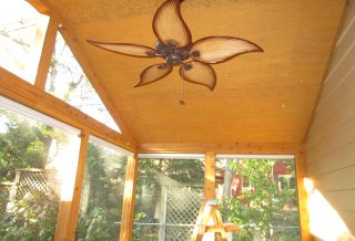 Roomy gable roof screened-in porch remodel with cedar trim and cathedral ceiling.