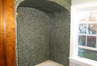 Tub with mosaic tile surround in bathroom remodel project in West Urbana, IL.